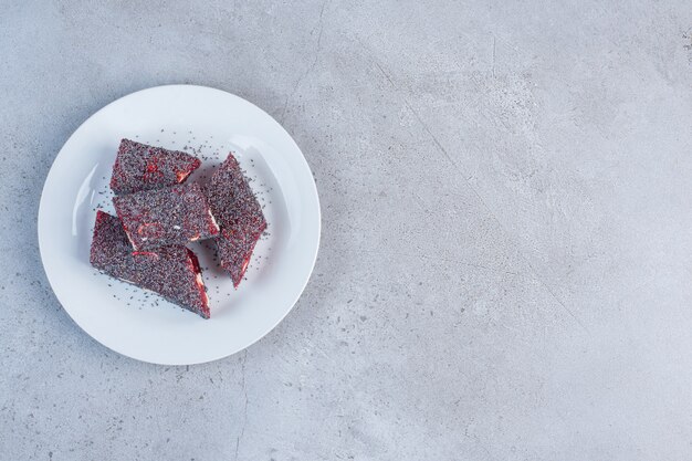 A serving of flavored and colored Turkish delights on a platter on marble background.