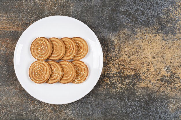 Sesame seeds biscuits on white plate.