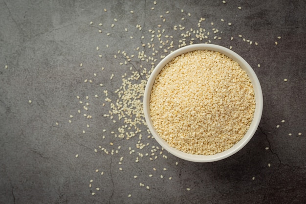 Sesame seeds in bowl on dark background