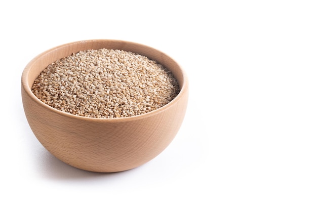 Sesame seeds in wooden bowl isolated on white background