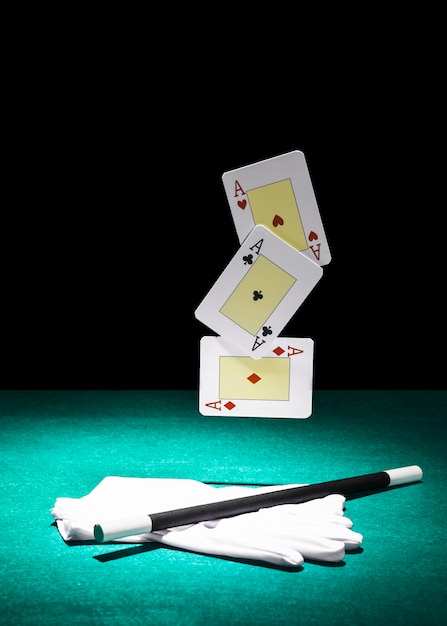 Free photo set of aces playing cards over the pair of white gloves with magic wand