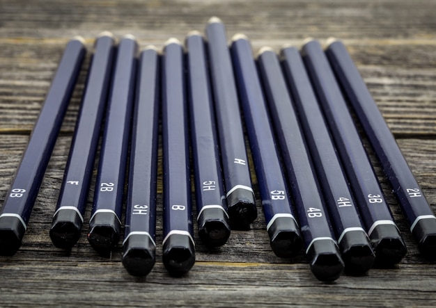 set of black pencils on wood beautifully arranged, closeup, macro