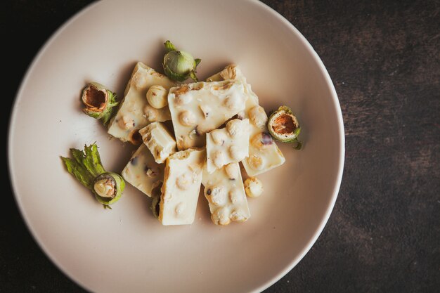 Set of chocolate and pistachio in a bowl on a dark textured.