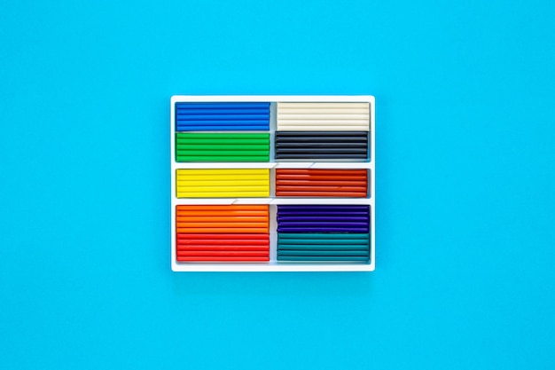 Free photo set of colorful plasticine sticks isolated on a blue background top view