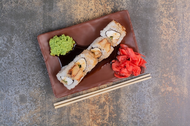 Set of delicious sushi with chopsticks and ginger on marble space