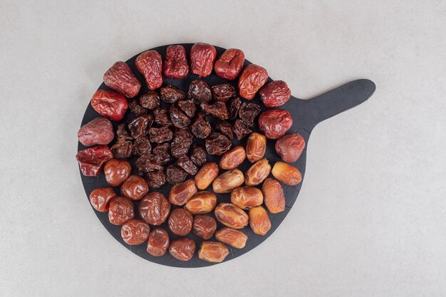 Set of dry fruits on a wooden platter.