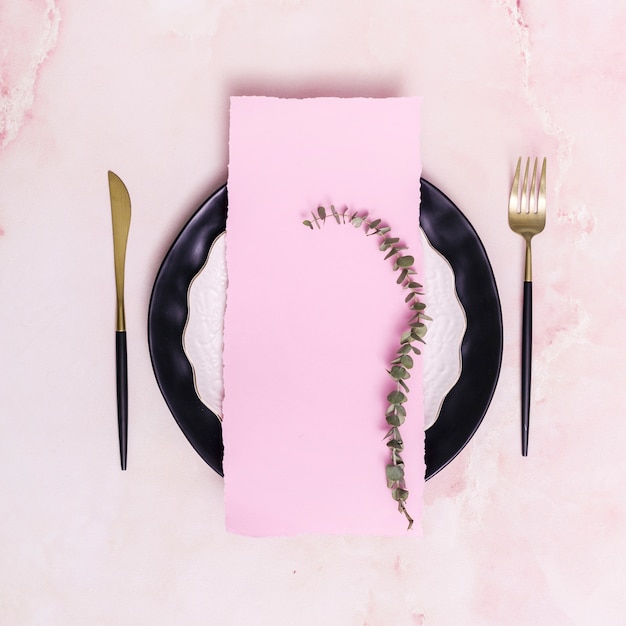 Free photo set of dry twig and paper on plate near cutlery