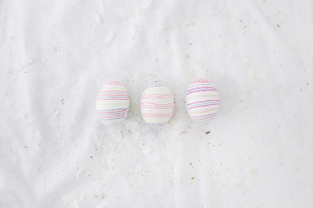 Free photo set of easter eggs with patterns and feathers on textile