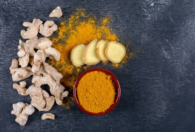 Free Photo set of ginger slices and powder and ginger in a bowl on a dark textured background. top view. space for text