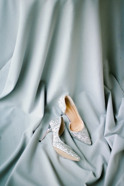 Free photo set of gray cloth and heels and wedding decoration on a gray textured background. top view.