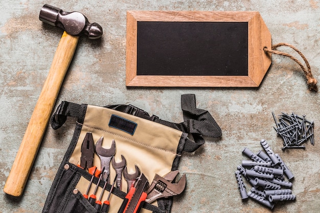 Free Photo set of hand tool with nails and small tag slate on grunge backdrop