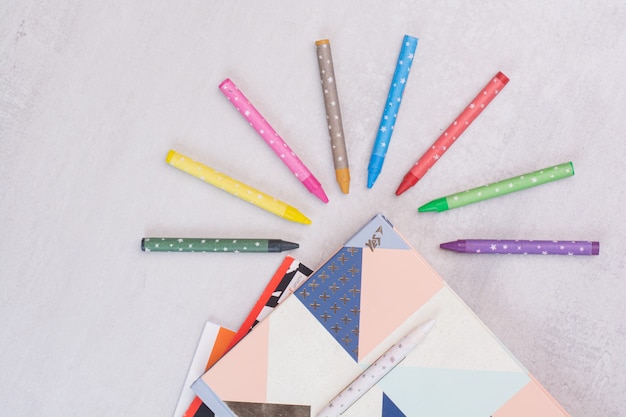 Free Photo set of notebooks and colorful pencils on white surface