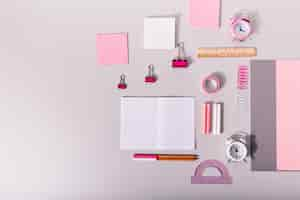 Free photo set of office supplies for work in pastel pink colors on isolated wall