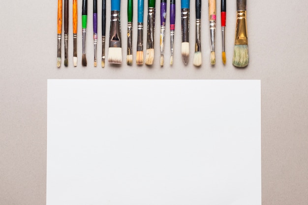 Free photo set of paintbrushes near paper