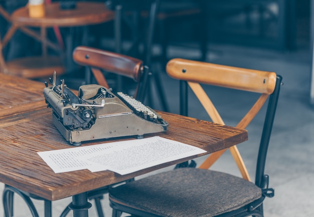 Free photo set of papers and typewriter on table in cafe terrace, side view.