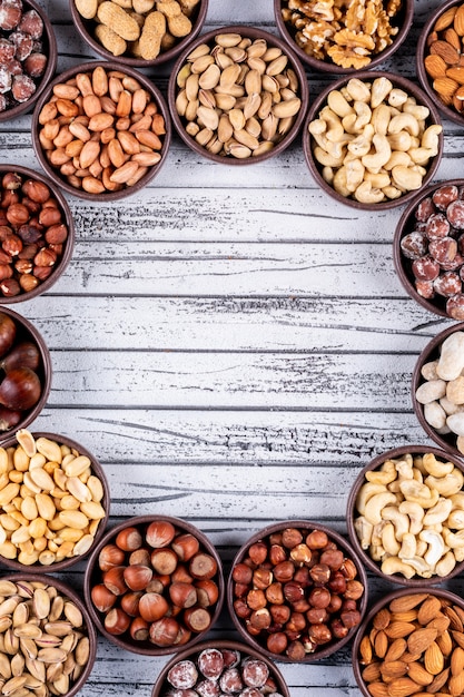 Set of pecan, pistachios, almond, peanut, and assorted nuts and dried fruits in a cycle shaped mini different bowls