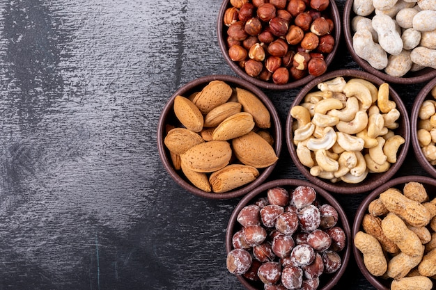 Set of pecan, pistachios, almond, peanut, cashew, pine nuts and assorted nuts and dried fruits in a mini different bowls