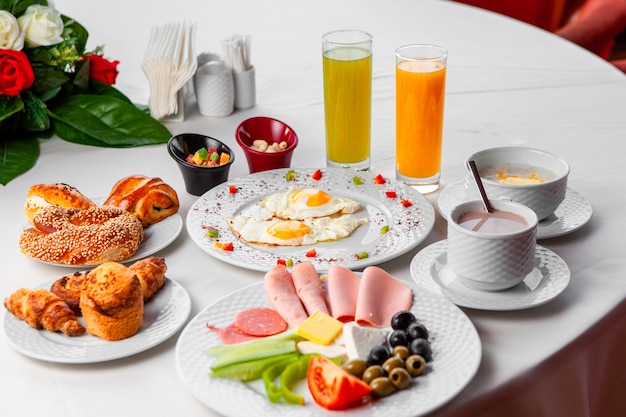 Set of salad, fried eggs and pastry and delicious breakfast in a table on a white background. high angle view.