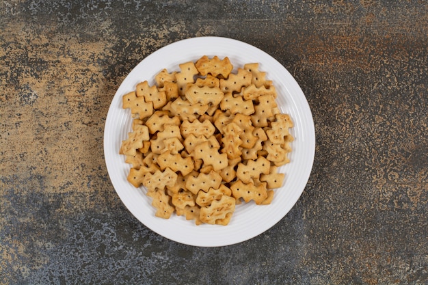 Set of salty crackers on white plate.