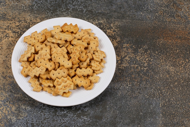 Set of salty crackers on white plate.