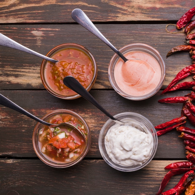 Free photo set of sauces in bowls with spoons near chili