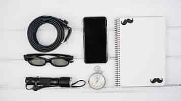 Free photo set of smartphone near notebook and male accessories