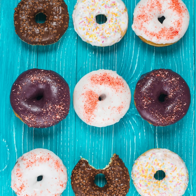 Set of tasty bitten doughnuts with chocolate coating and sprinkles