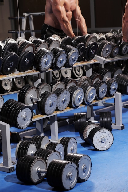 A set up with many dumbbells and a man