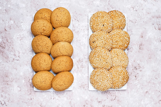 Set of various american style cookies on a light concrete background. Shortbread with confetti, sesame seed, peanut butter, oatmeal and chocolate chip cookies.