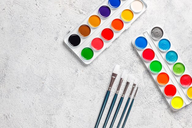 Set of watercolor paints and paintbrushes for painting.