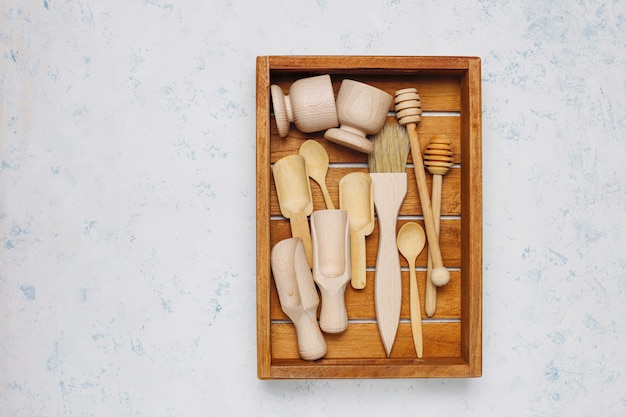 Free photo set of wooden kitchen utensils on concrete surface