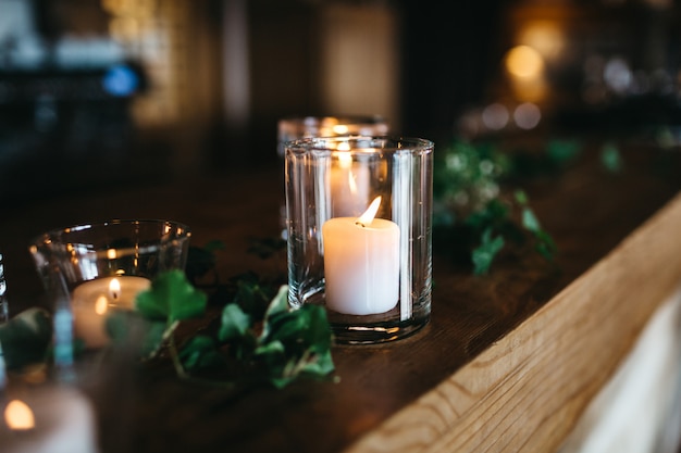 Free photo several candles stand on wooden shelf