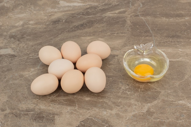 Several eggs with raw egg on the plate in the marble surface 