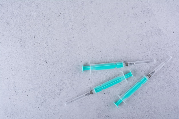 Free Photo several empty syringes on marble background. high quality photo