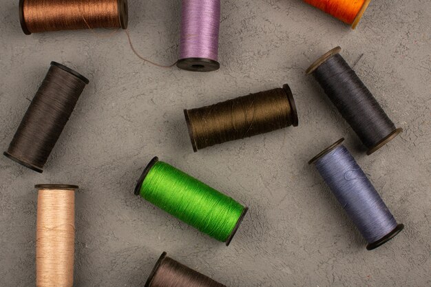 Sewing threads colorful on a grey desk