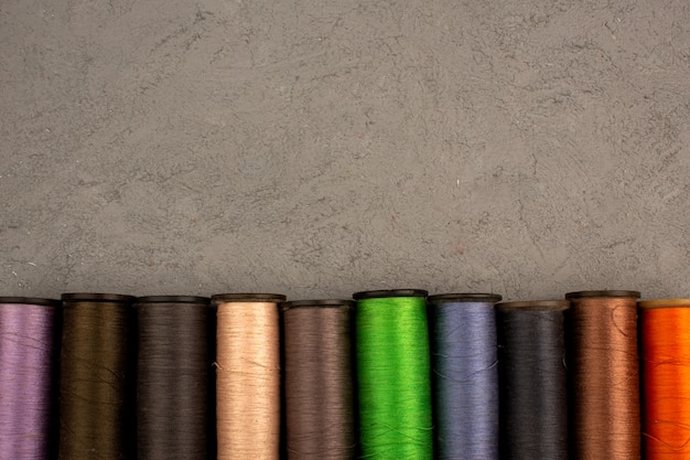 Sewing threads multicolored various on a grey background