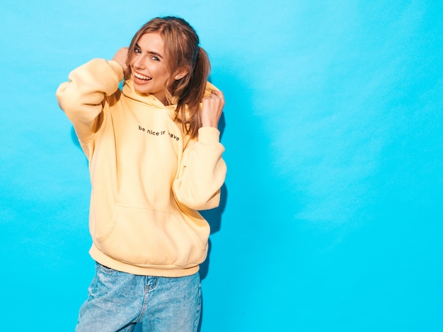 Free Photo sexy carefree woman posing near blue wall. positive model having fun