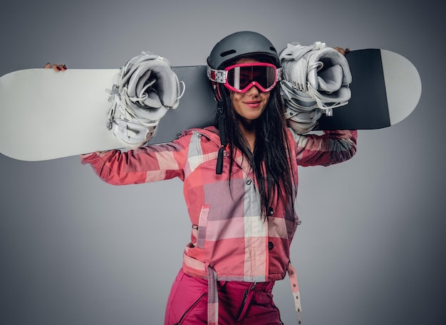 Free Photo sexy female in ski costume posing with snowboard in a studio on grey background.