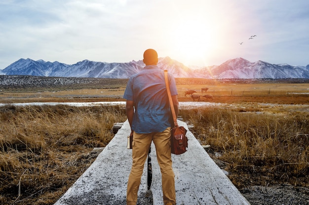 Free Photo shallow focus from behind of a male standing on a pathway in the middle of a grassy field