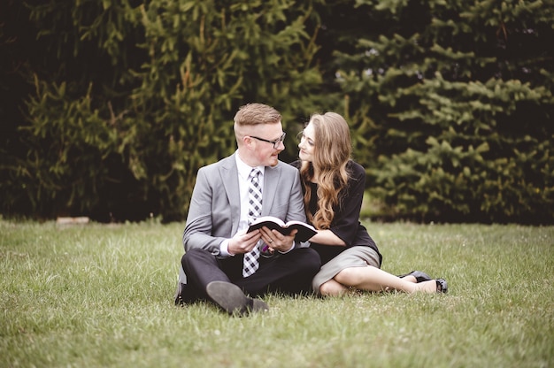 Free photo shallow focus shot of a couple talking and enjoying each others company while sitting in a garden