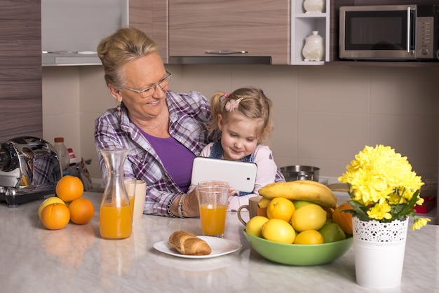 Shallow focus shot of a grandmother looking at the smartphone with her grandchild