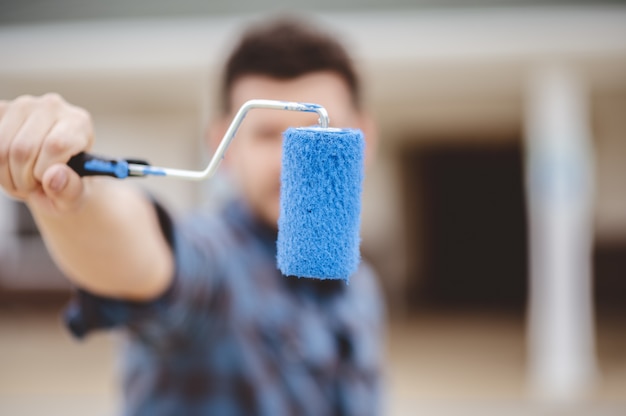 Free photo shallow focus shot of a male holding a blue colored brush