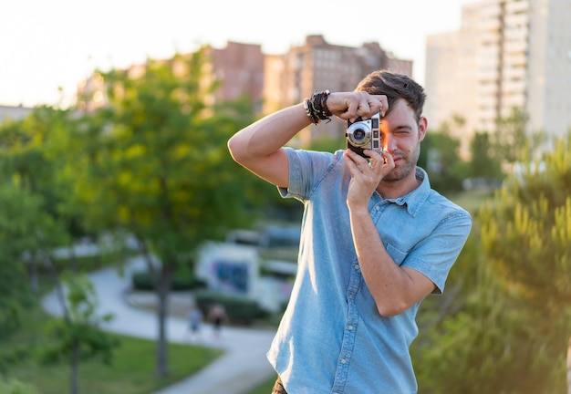 Shallow focus shot of a young male taking a photo in the park