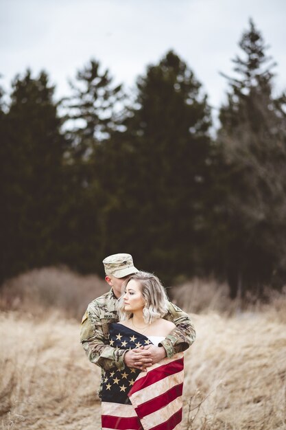 Shallow focus vertical shot of an American soldier hugging his wife