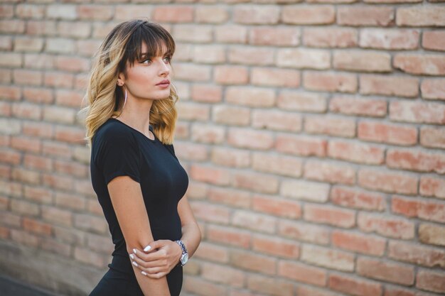 Shallow focus of a young Bosnian woman with a brick wall background