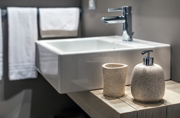 Free photo shallow shot of a modern sink beside the bottle in the bathroom