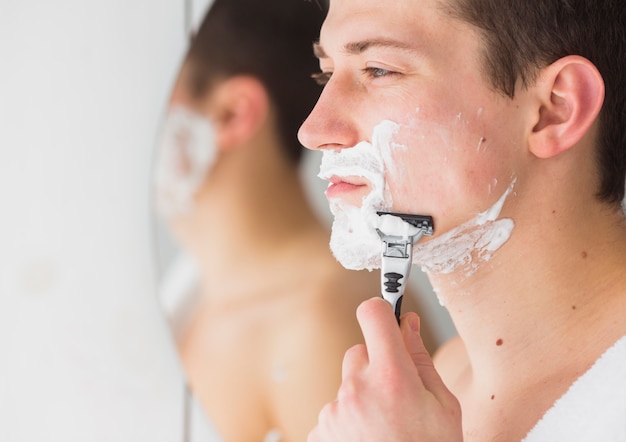 Shaving concept with attractive young man