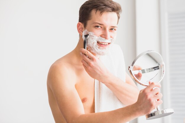 Shaving concept with attractive young man