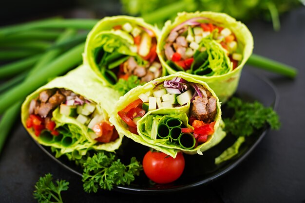 Free Photo shawarma from juicy beef, lettuce, tomatoes, cucumbers, paprika and onion in pita bread with spinach. diet menu