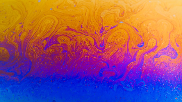 Free photo shimmering wavy purple and orange abstract background